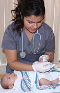 Nurse performing the newborn screening test on an infant.