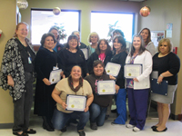 The cheerful staff of the Hobbs public health office posing with smiles on their faces while holding the certificates which honor them.